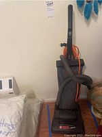 Full view of Hoover Commercial vacuum cleaner showing upright design with handle, hose, and power cord.