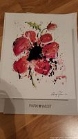 Photo of Serio lithograph featuring a red and pink flower, signed by artist with PARK WEST branding visible below the print.