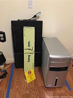 Photo of Hang Onn tabletop TV stand alongside Dell Inspiron 530 computer case and no smoking sign on the floor.