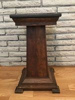 Front view of the oak plant stand showing tapered column and base