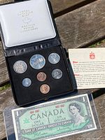 Photo of the Royal Canadian Mint coin set in black case with white lid showing seven Canadian coins of various denominations and sizes, with a leaflet.
