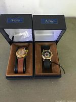 Two collectible wristwatches (Mickey Mouse and Snoopy), new with tags, in their original Nino branded display boxes, shown side by side.