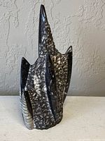 Front angled view of large Orthoceras fossil sculpture showing polished and rough textures with multiple fossils visible.
