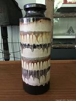 Front view of the cylindrical vintage West Germany pottery vase showing the textured glaze with drips in multiple shades of brown and cream.