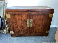 Front view of dark wood buffet cabinet with brass hinges and handles.