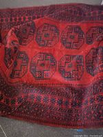 Photo showing the central pattern area with octagonal medallions and overall red and dark blue color scheme, highlighting wear and dirt.