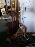 Image showing a metal ashtray stand, folding wooden plant stand, and a white metal towel rack with circular holders all together.