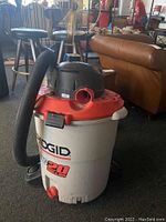 Ridgid Big 20 Gallon Shop Vacuum with attached hose, showing the front and side view including logo and capacity label.