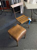 Photo showing both vintage folding metal frame chair with wooden seat and the leather upholstered foot stool together