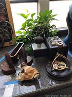 Overall view of the lot items including kaleidoscope, potted plant, doll, textured cube object, and wooden stand