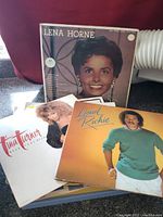 Three vinyl albums arranged showing faces of Lena Horne, Lionel Richie, and Tina Turner on covers.