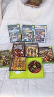 Photo showing five Xbox game cases including Need for Speed Underground, Harry Potter Quidditch World Cup, Star Wars Starfighter, Mercenaries, and The Punisher