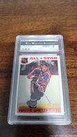 Front image of the 1985 Wayne Gretzky All Star NHL hockey card in a protective case showing the player in Edmonton Oilers jersey.