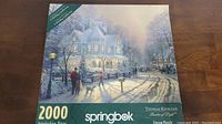 Front view of the puzzle box showing the winter scene image and brand name Springbok, plus Thomas Kinkade credit
