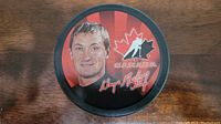 Top side of the puck showing Wayne Gretzky's image, Canada logo, and signature