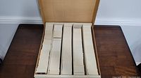Large monster box filled with stacks of trading cards divided into several columns using cardboard dividers