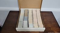 Photo showing 5000 trading cards neatly organized in a white monster box divided into five sections.