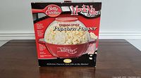 Front view of the Betty Crocker Movie Nite Cinema-Style Popcorn Popper box showing product image and features.