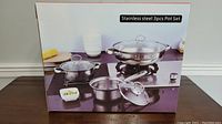 Box showing image of 3pc stainless steel pot set with lids on a kitchen counter.
