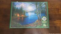 Box top showing complete Cobble Hill 1000 piece puzzle artwork titled 'Summer Nights', featuring a lake, forest, tents, and moonlight.