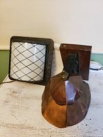 Two vintage lamps: one copper Arts & Crafts wall lamp with multi-faceted shade and a glass Deco ceiling lamp with black metal cage