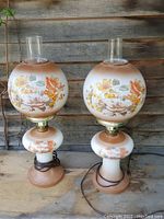 Full view of both vintage 1970s Gone with the Wind style glass electric lamps with floral details shown from front and side angles