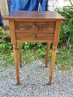 Front view of table on gravel surface with greenery background