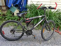 Full side profile of the black CCM mountain bike showing the entire frame, tires, seat, handlebars, and gear system.