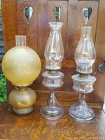 Full view of the three coal oil lamps showing their overall shape, condition, and components.