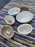 Top view of all six antique ceramic jelly molds showing various shapes and wear.