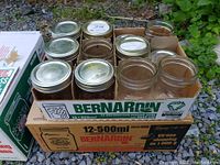 Boxed set of Bernardin 500ml mason jars, some filled and some empty, with metal lids.