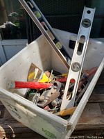 Mixed lot of various hand tools including levels, saw, pipe wrench, spade, screwdrivers in a white plastic bin