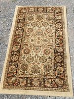 Full view of the decorative rug runner/mat laid flat on a gravel surface showing color, pattern, and size