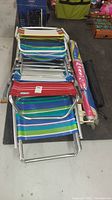 Top view of stacked colorful beach chairs with metal frames and various striped fabric patterns