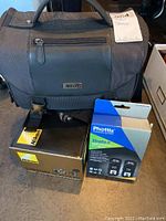 Nikon camera bag, Nikon camera kit box and Phottix Strato II box arranged on table.