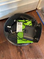 Top view of Roomba vacuum with power adapter and labels visible