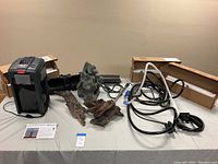 Photo showing a black Flow Pro canister aquarium filter, tubing, decorative rocks, and driftwood pieces on a table.