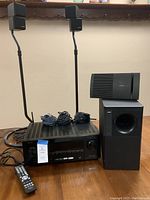Front view of Denon receiver, remote, speaker cables, stands and Bose speakers