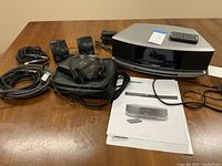 Overview of all items in the lot: Bose system, Sony speakers, Panasonic CD player, headphones, case and cables