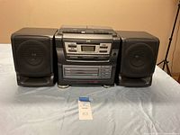 Full front view showing the central stereo system and two detachable speakers on either side.