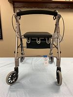Front-facing photo showing the Merits walker with padded seat and storage underneath.