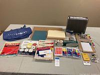Full view of the lot showing file organizer, manila folders, clipboards, calculator, hole punch, packs of colored dot stickers, laser label sheets, and adjustable clear plastic stand