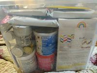 View of clear plastic tub filled with various sealed cake decorating supplies with visible front labels and nutrition facts.
