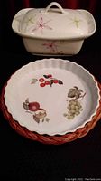 Photo showing side and top view of the rectangular floral casserole dish with lid and the round quiche dish with fruit pattern and scalloped edges.