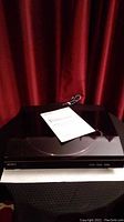 Closed Sony turntable with instructions booklet and connecting cable on top.