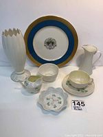 View of all porcelain items together showing Lenox plate, pitcher, vase and Belleek teacup set with creamer and bowl