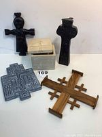 Overall view of all 5 items: two dark Celtic crosses, wooden Jerusalem cross, plaster Russian Orthodox crucifixion cross, and reproduction trinket box