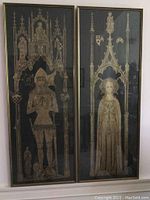 Overall view of the pair of framed medieval brass rubbings hung side by side, showing full figures and framing details