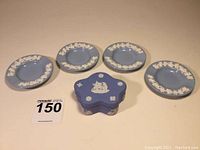 Photo showing one star-shaped trinket box with lid and four small matching dishes in blue Jasperware with white relief decoration.