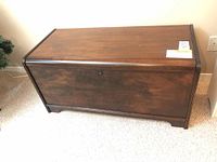 Front and side views of the dark-stained antique wood chest with cedar lining and hinged lid.